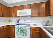 Thumbnail 21 of 25 - Spacious kitchen with custom home cabinets, recessed ceiling, and side-by-side refrigerator at Tuscany Park Apartments in Houston.
