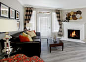 Thumbnail 18 of 36 - Luxury apartments with spacious living room, wood burning fireplace,  French door, lots of natural light, and gray colored walls at Lenox Village Apartments in Lincoln, NE.