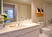 Thumbnail 64 of 73 - Luxury bathroom with white cabinets, cultured marble vanity, oval soaking tub, and glass shower at The Saxony Apartments