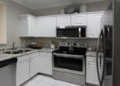 Thumbnail 28 of 38 - Luxury apartments with granite countertops, white cabinets, stainless steel appliances, and side-by-side refrigerator at TurtleCreek apartments in West Des Moines, Iowa
