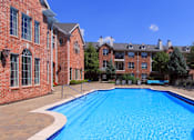Thumbnail 4 of 38 - Luxury apartments with red brick exterior, huge swimming pool, poolside lounge chairs, and lush landscaping at TurtleCreek apartments in West Des Moines, Iowa