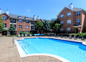 Thumbnail 27 of 38 - Luxury apartments with red brick exterior, huge swimming pool, poolside lounge chairs, grilling station, and lush landscaping at TurtleCreek apartments in West Des Moines, Iowa