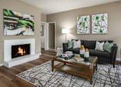 Thumbnail 7 of 42 - Spacious living room with wood burning fireplace and grey painted walls at Woodlake on the Bayou Apartments in Houston.