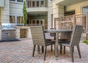 Thumbnail 40 of 42 - Resident grilling station and sitting area in the courtyard at Tuscany Walk Apartments in Houston Texas