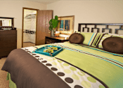 Thumbnail 25 of 35 - A bedroom with a bed, nightstand, and a dresser.