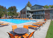 Thumbnail 19 of 35 - A pool surrounded by orange chairs and tables.