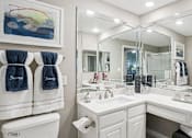 Thumbnail 13 of 73 - Luxury bathroom with white cabinets, cultured marble vanity, oval soaking tub, and glass shower at The Saxony Apartments in Dallas