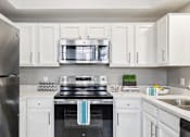 Thumbnail 55 of 73 - Luxury apartments with kitchens with white cabinets and stainless-steel appliances at The Saxony Apartments in Dallas
