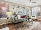 Thumbnail 49 of 73 - Spacious living room with wood plank floors, French door, and oversized windows at The Saxony Apartments in Dallas