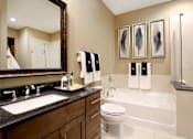 Thumbnail 19 of 42 - Spacious bathroom with oval soaking tub, separate shower with glass enclosure, and granite slab vanity top Tuscany Walk Apartments in Houston.