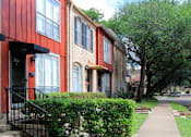 Thumbnail 1 of 23 - A row of red and beige townhouses with black doors and windows.