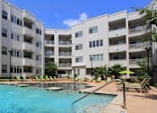 Thumbnail 10 of 29 - A swimming pool in front of apartment buildings.