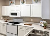 Thumbnail 3 of 37 - Luxury apartments with spacious kitchen, full-size washer and dryer, breakfast bar, and white cabinets at Kensington Square Apartments.