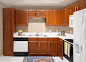 Thumbnail 16 of 22 - a kitchen with wooden cabinets and white appliances