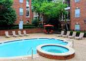 Thumbnail 21 of 22 - Gated community near the Galleria with brick exteriors, lush landscaping, two swimming pools with poolside lounge chairs, spa, and sauna at The Dorchester Apartments in north Dallas.