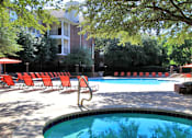 Thumbnail 10 of 22 - Gated community near the Galleria with brick exteriors, lush landscaping, two swimming pools with poolside lounge chairs, spa, and sauna at The Dorchester Apartments in north Dallas.