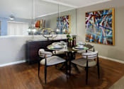 Thumbnail 17 of 36 - Luxury apartments with spacious dining room, wood plank floors, breakfast bar, mirror accent wall, and 9-foot ceilings at Kensington Square Apartments.
