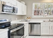 Thumbnail 25 of 73 - Luxury apartments with kitchens with white cabinets and stainless-steel appliances at The Saxony Apartments in Dallas