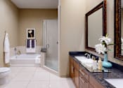 Thumbnail 6 of 42 - Spacious bathroom with oval soaking tub, separate shower with glass enclosure, cultured marble vanity at Tuscany Walk Apartments in Houston