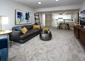 Thumbnail 4 of 43 - A living room with a grey couch and a coffee table.