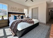 Thumbnail 21 of 28 - A bedroom with a large bed and a ceiling fan.