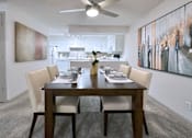 Thumbnail 2 of 43 - A dining room with a table set for two and a painting on the wall.