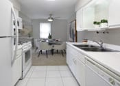 Thumbnail 6 of 20 - Bright white kitchen with lots of cabinet space, porcelain tile floor, and spacious dining room at Inwood Apartments in La Vista, Nebraska