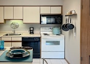 Thumbnail 26 of 35 - Fully-equipped kitchen with lots of cabinet space, built-in breakfast bar and tiled floors at LionsHead Apartments in Omaha Nebraska