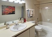 Thumbnail 7 of 35 - Spacious bathroom with tiled shower, tiled floors, lots of cabinet space, and extra storage space at LionsHead Apartments in Omaha Nebraska