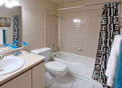 Thumbnail 24 of 35 - Spacious bathroom with tiled shower, tiled floors, lots of cabinet space, and extra storage space at LionsHead Apartments in Omaha Nebraska