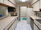 Thumbnail 4 of 35 - Kitchen with abundant countertop space and cabinets, granite breakfast bar, glass top stove, and separate laundry room at LionsHead Apartments in Omaha Nebraska