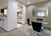 Thumbnail 21 of 35 - Dining room area with painted feature wall, granite breakfast bar, and kitchen with tiled floor at LionsHead Apartments in Omaha Nebraska