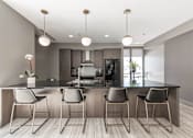Thumbnail 1 of 41 - A modern kitchen with a bar area featuring four chairs.