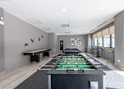 Thumbnail 7 of 41 - A room with a foosball table and a pool table.
