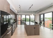 Thumbnail 13 of 41 - A modern kitchen with a large island in the middle.