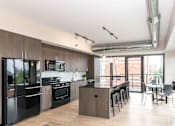 Thumbnail 16 of 41 - A modern kitchen with a dining table and chairs.