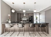 Thumbnail 20 of 41 - A modern kitchen with a bar area featuring four chairs.