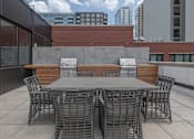 Thumbnail 25 of 41 - A table surrounded by chairs on a rooftop patio.