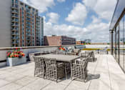 Thumbnail 29 of 41 - A patio with a table and chairs overlooks a cityscape.