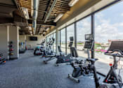 Thumbnail 31 of 41 - A gym with a row of exercise bikes and a television.