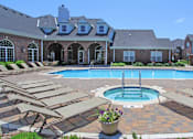 Thumbnail 4 of 31 - Luxury apartments with red brick exteriors, swimming pool, pool-side lounge chairs, beautiful landscaping, and scenic views at Rockledge Oaks Apartments in Lincoln, Nebraska