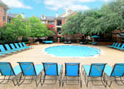 Thumbnail 15 of 73 - Gated community near the Galleria with brick exteriors, lush landscaping, two swimming pools with poolside lounge chairs, spa, and sauna at The Saxony Apartments