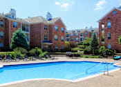 Thumbnail 20 of 38 - Luxury apartments with red brick exterior, huge swimming pool, poolside lounge chairs, grilling station, and lush landscaping at TurtleCreek apartments in West Des Moines, Iowa