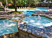 Thumbnail 4 of 30 - Luxury apartments with beautiful fountains, beautiful landscaping, swimming pool with poolside lounge chairs, and scenic views at Preston Village Apartments in north Dallas