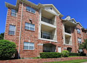 Thumbnail 22 of 73 - Gated luxury apartment community in north Dallas with red brick exteriors, large patio, and beautiful landscaping at The Saxony Apartments