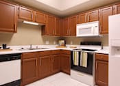 Thumbnail 13 of 20 - Luxury apartments with spacious kitchens, custom home cabinets, and side-by-side refrigerators at Tuscany Gate Apartments in Houston.