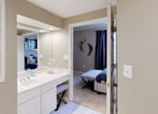 Thumbnail 10 of 20 - Luxury apartments with spacious bathrooms with glass showers, oval soaking tubs, built-in shelves, spacious linen closets, and cultured marble vanities at Tuscany Gate Apartments in Houston.