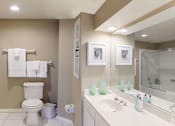 Thumbnail 5 of 73 - Luxury apartments with spacious bathrooms with tiled floors, linen closet, oval soaking tubs, built-in vanity, cultured marble vanity, glass shower and white cabinets in at The Saxony Apartments