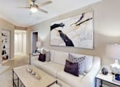 Thumbnail 2 of 20 - Spacious living room with wood-burning fireplace with glass doors, ceiling fan, crown molding, and built-in bookshelves at Tuscany Gate Apartments in Houston.