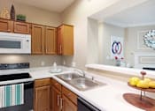 Thumbnail 5 of 20 - Luxury apartments with spacious kitchens, custom home cabinets, and breakfast bars at Tuscany Gate Apartments in Houston.